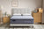 Gray mattress with 'Morrison' and Good Morning' branding in a bedroom setting.