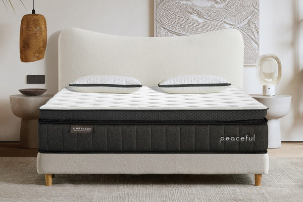 Mattress on a bed frame with 'peaceful' branding in a bedroom setting